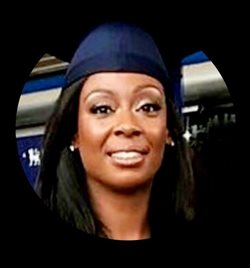 A smiling person wears a blue graduation cap, symbolizing academic achievement. The background is blurred, offering a celebratory and proud atmosphere.