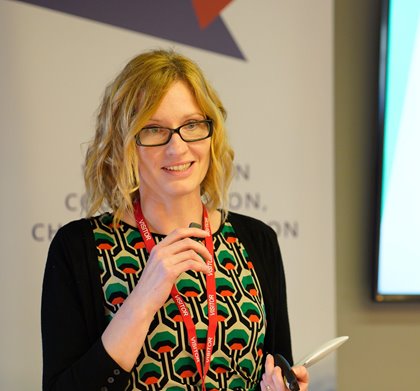 Photo of the Angela Needle holding the mic