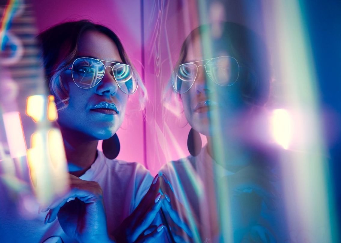 Woman Wearing Sunglasses In Illuminated Room