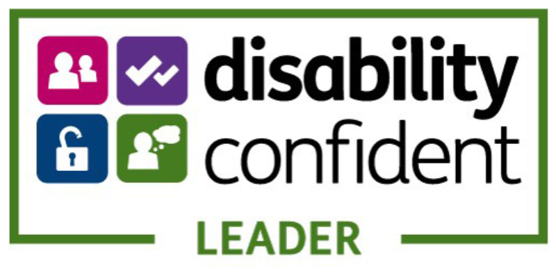 Disability Confident Leader logo featuring four coloured icons—a people icon, a checkmark, an open padlock, and a person with a speech bubble—next to the words ‘disability confident’ and the label ‘LEADER’ framed in green.