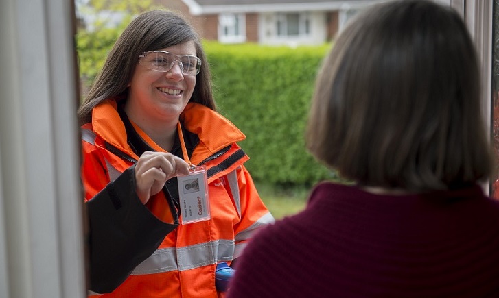 female engineer standing at door showing Cadent ID card