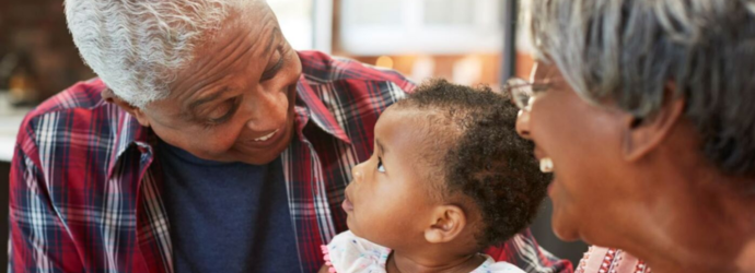 Two adults smiling and laughing with a young child